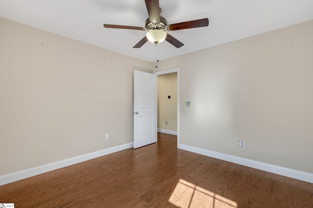 empty room featuring ceiling fan and dark wood-type flooring