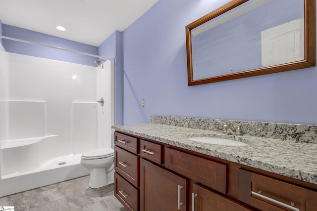 bathroom with walk in shower, vanity, and toilet