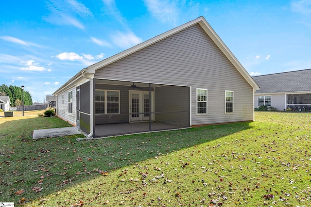 back of property with a sunroom, a yard, and a patio