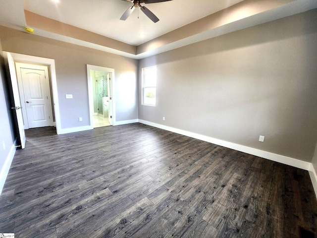 unfurnished bedroom featuring ensuite bath, ceiling fan, and dark hardwood / wood-style floors