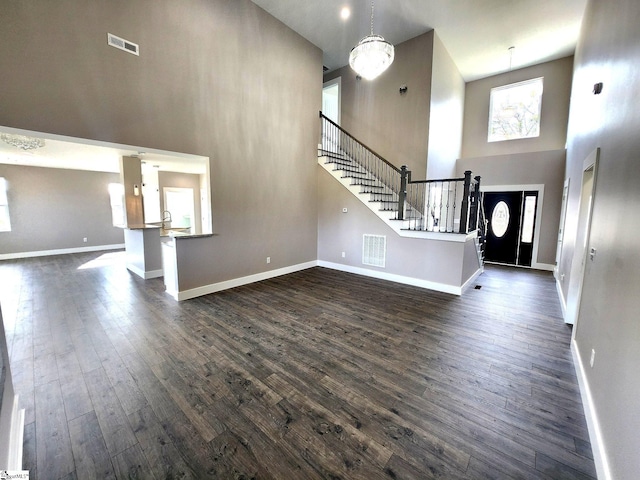 foyer with a towering ceiling and dark wood-type flooring