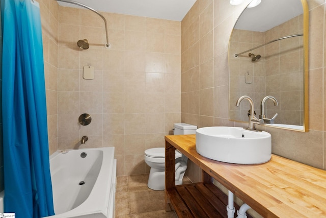 full bathroom featuring toilet, sink, shower / tub combo with curtain, and tile walls