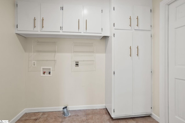 clothes washing area with cabinets, hookup for a washing machine, and light tile patterned floors