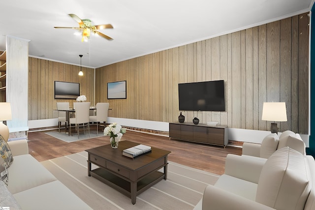 living room with light hardwood / wood-style floors, crown molding, and ceiling fan