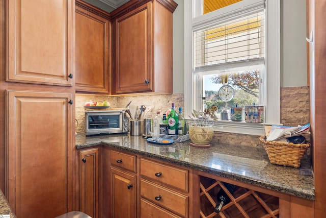 kitchen featuring decorative backsplash and dark stone countertops