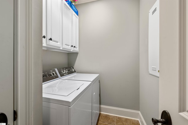 laundry area featuring cabinets, washing machine and dryer, and dark tile patterned floors