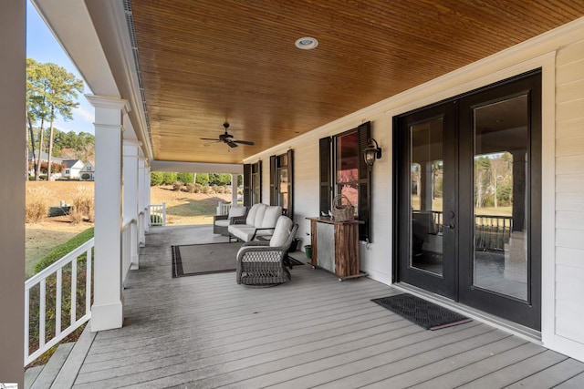 wooden terrace with ceiling fan, french doors, and covered porch