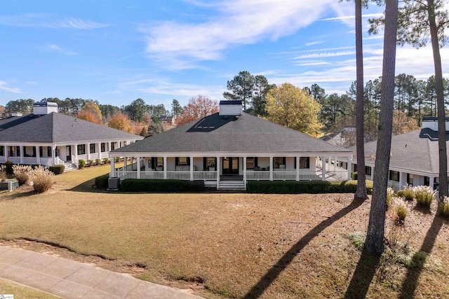 back of house with covered porch and a yard