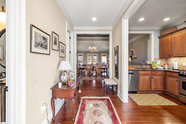 interior space featuring an inviting chandelier, crown molding, dark hardwood / wood-style floors, appliances with stainless steel finishes, and decorative light fixtures