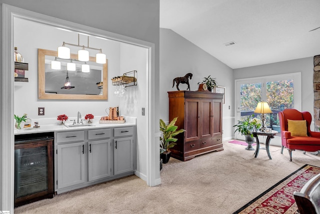 living area with indoor wet bar, lofted ceiling, light carpet, and wine cooler