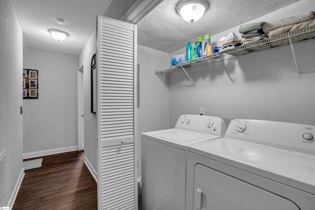 laundry area with dark hardwood / wood-style floors, separate washer and dryer, and a textured ceiling