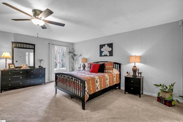 bedroom featuring a textured ceiling, ceiling fan, and light carpet