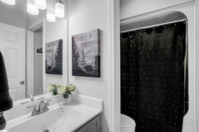 bathroom featuring vanity, toilet, and walk in shower