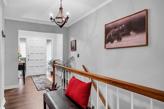 entryway featuring crown molding, wood-type flooring, and a notable chandelier