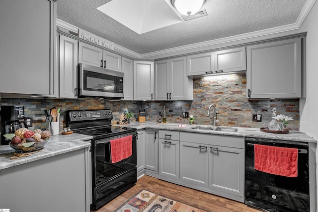 kitchen with decorative backsplash, ornamental molding, sink, black appliances, and light hardwood / wood-style flooring