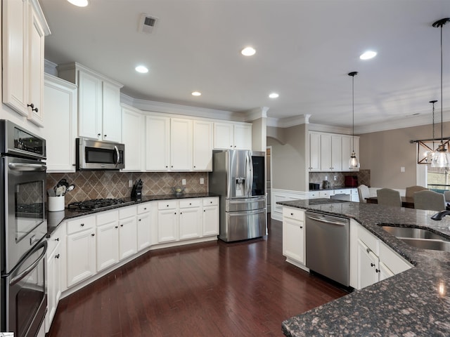 kitchen with sink, hanging light fixtures, dark hardwood / wood-style flooring, white cabinets, and appliances with stainless steel finishes