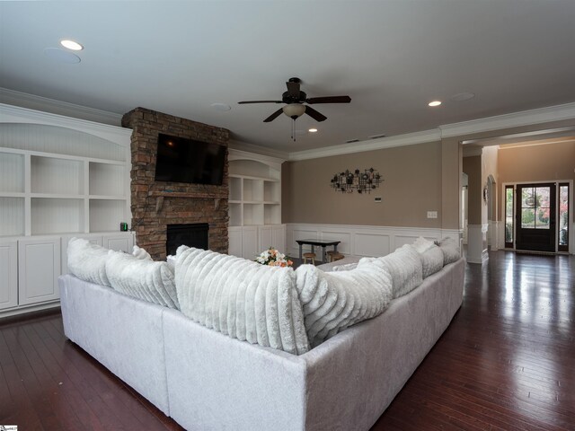 living room with a fireplace, ceiling fan, crown molding, and dark wood-type flooring