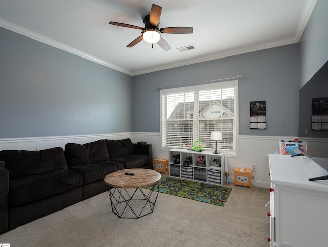 carpeted living room with ceiling fan and crown molding