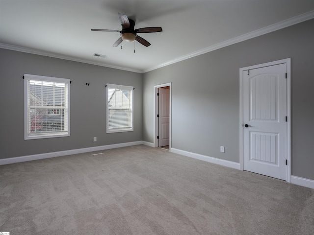 empty room featuring ceiling fan, light colored carpet, and ornamental molding