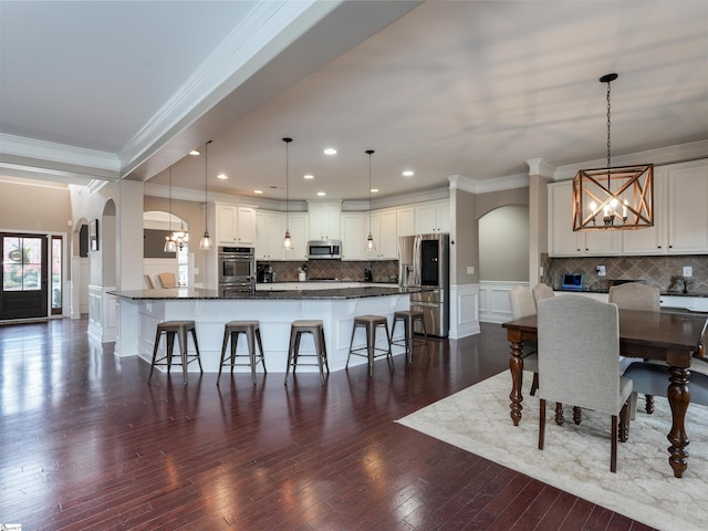 dining space with crown molding, dark hardwood / wood-style flooring, and an inviting chandelier