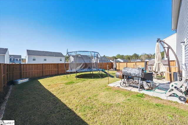 view of yard with a trampoline and a patio area