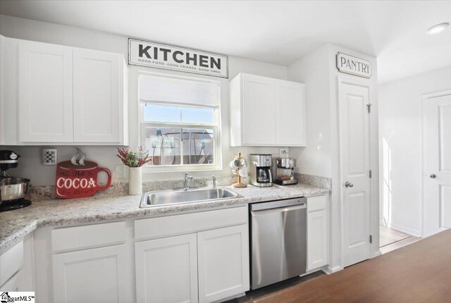 kitchen with dishwasher, sink, white cabinets, and light stone counters