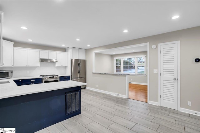 kitchen with kitchen peninsula, white cabinets, and stainless steel appliances