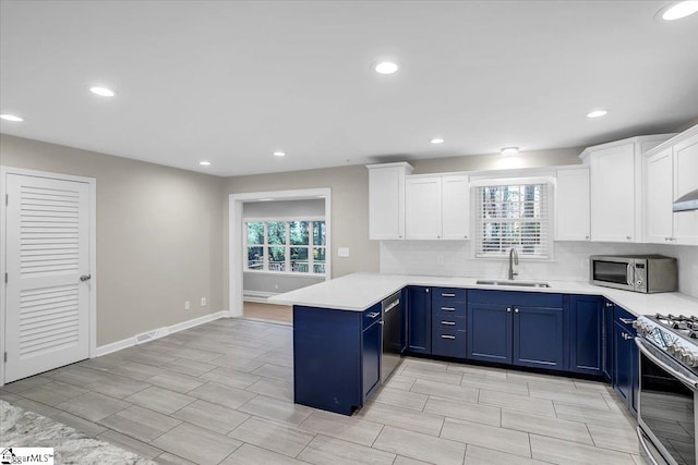 kitchen with white cabinetry, kitchen peninsula, stainless steel appliances, and a wealth of natural light