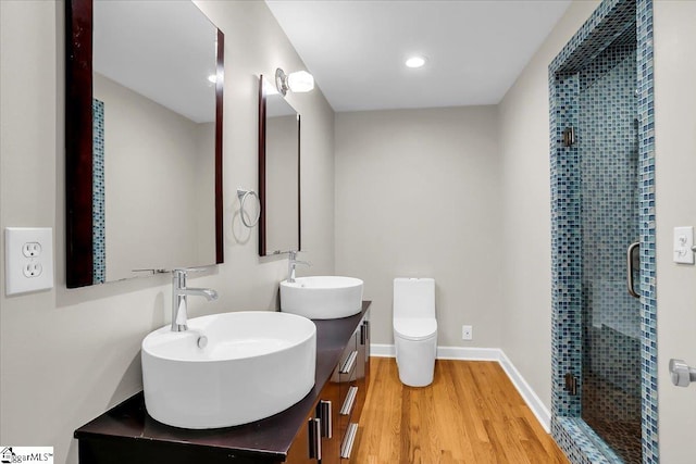 bathroom featuring vanity, hardwood / wood-style flooring, toilet, and an enclosed shower