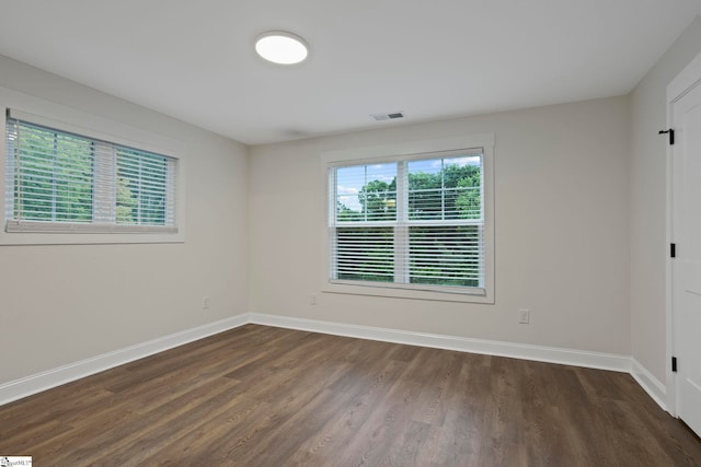 empty room with dark hardwood / wood-style flooring