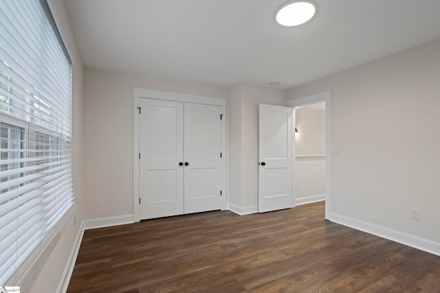 unfurnished bedroom with dark hardwood / wood-style flooring and a closet