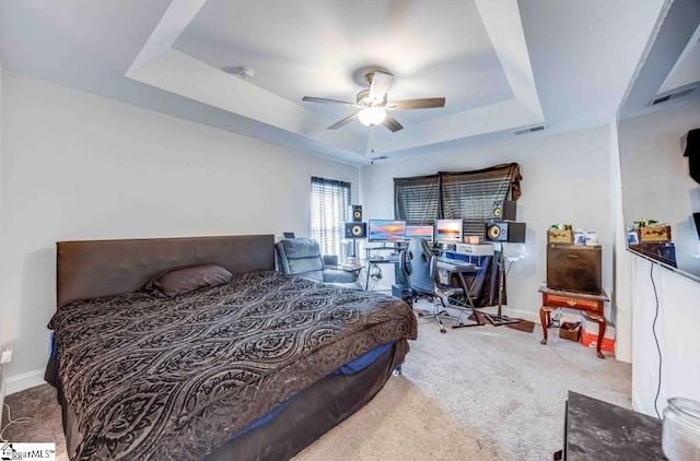 bedroom featuring carpet flooring, a raised ceiling, and ceiling fan