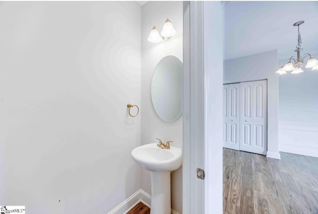 bathroom featuring hardwood / wood-style floors and an inviting chandelier