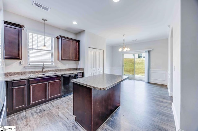 kitchen featuring dishwasher, a center island, sink, light hardwood / wood-style flooring, and pendant lighting