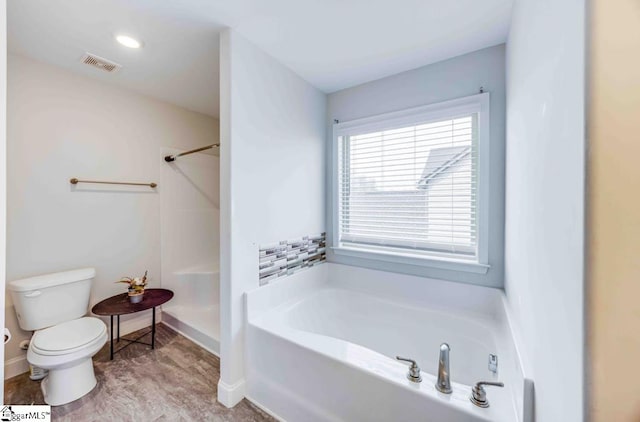 bathroom featuring a tub to relax in and toilet