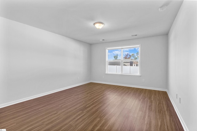 spare room with dark hardwood / wood-style floors