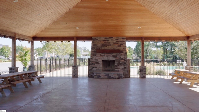 view of patio with a gazebo and an outdoor stone fireplace