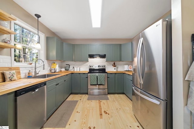 kitchen featuring backsplash, pendant lighting, wooden counters, and appliances with stainless steel finishes