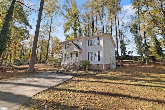 view of front of home with central AC unit and a front lawn