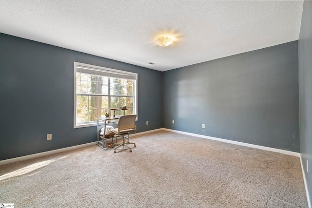 carpeted empty room with a textured ceiling