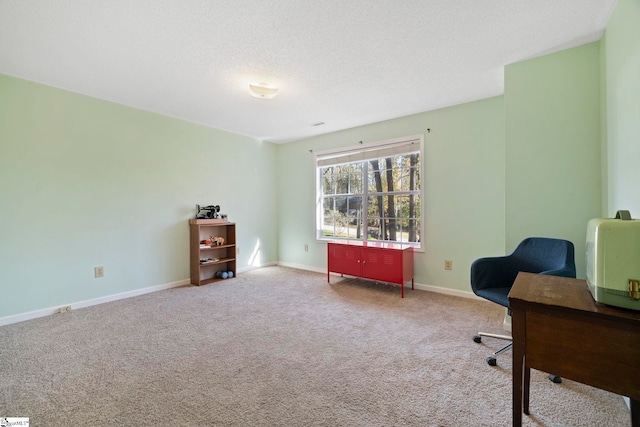 carpeted home office featuring a textured ceiling