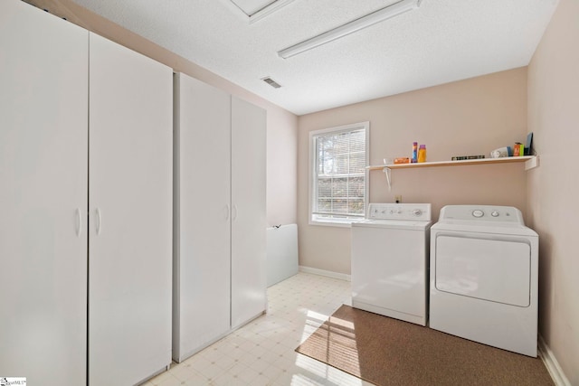 laundry room with washer and clothes dryer and a textured ceiling