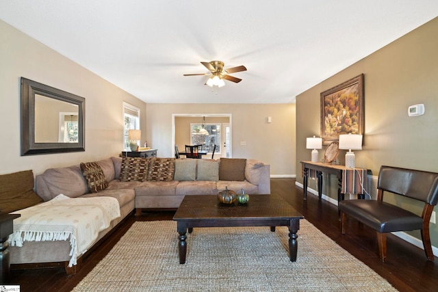 living room featuring ceiling fan and dark hardwood / wood-style floors