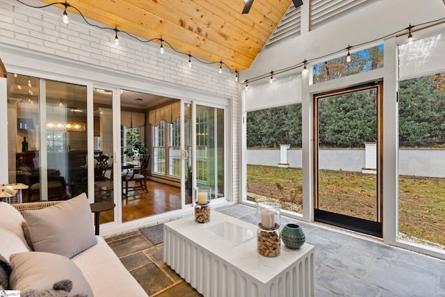 sunroom featuring ceiling fan, lofted ceiling, a wealth of natural light, and wooden ceiling