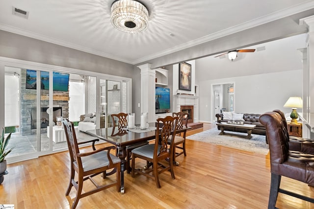 dining room with plenty of natural light, ornamental molding, ceiling fan with notable chandelier, and light wood-type flooring