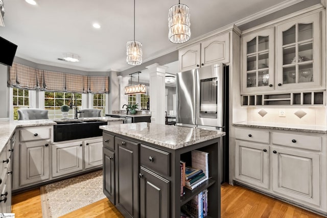 kitchen featuring gray cabinets, light wood-type flooring, and crown molding