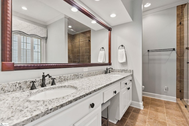 bathroom featuring vanity, toilet, a shower with door, and crown molding