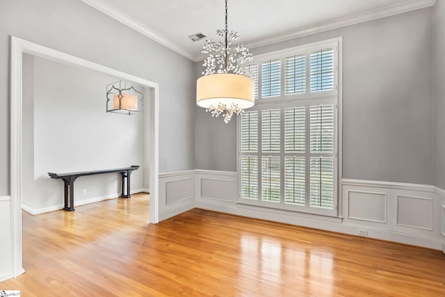 empty room with a chandelier, hardwood / wood-style floors, and a healthy amount of sunlight