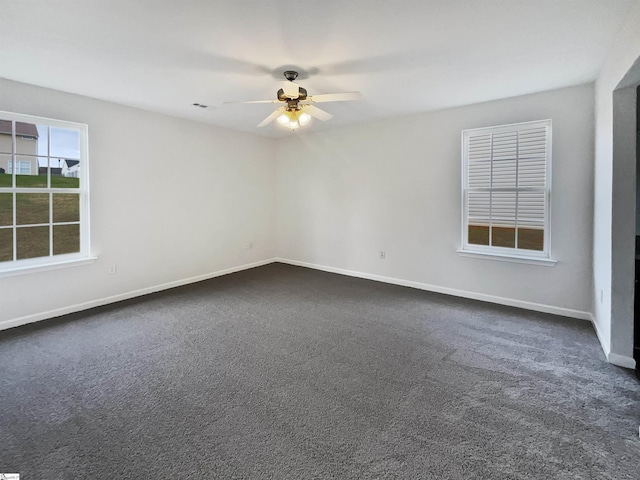 empty room featuring dark colored carpet and ceiling fan