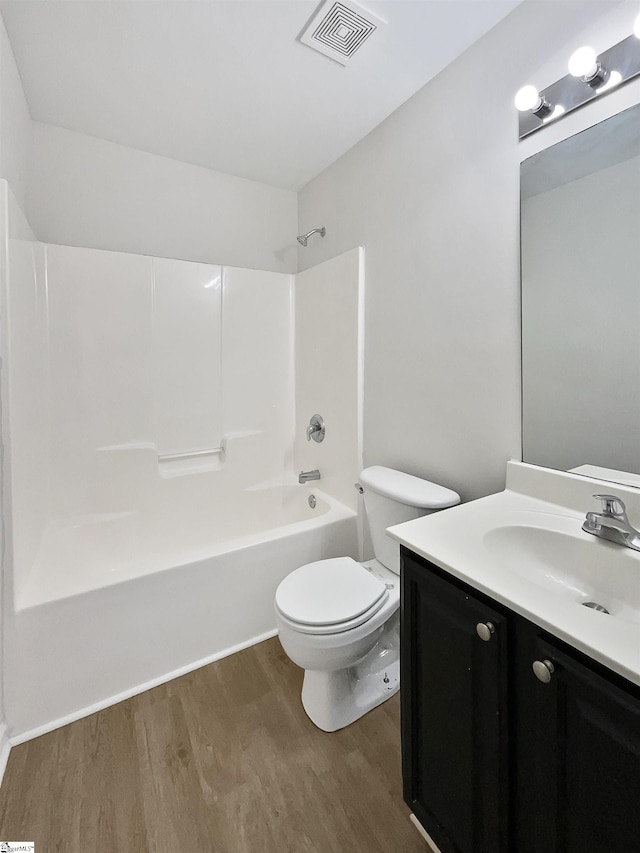 full bathroom featuring bathing tub / shower combination, toilet, vanity, and hardwood / wood-style flooring